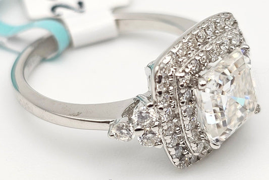 Diamond ring with a large central gemstone and smaller stones on a white background